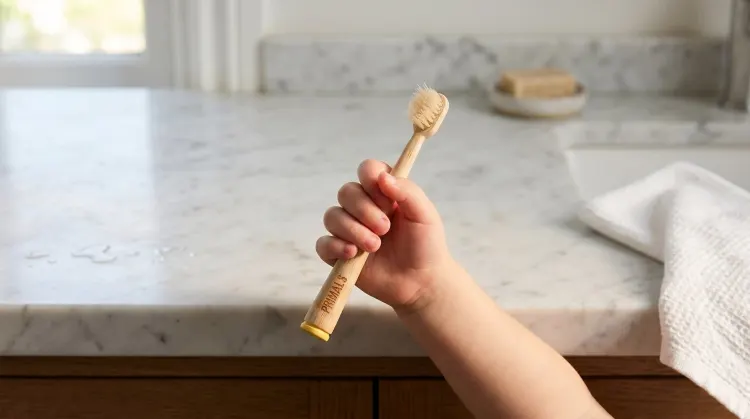 Child holding PRIMALS Kids bamboo toothbrush