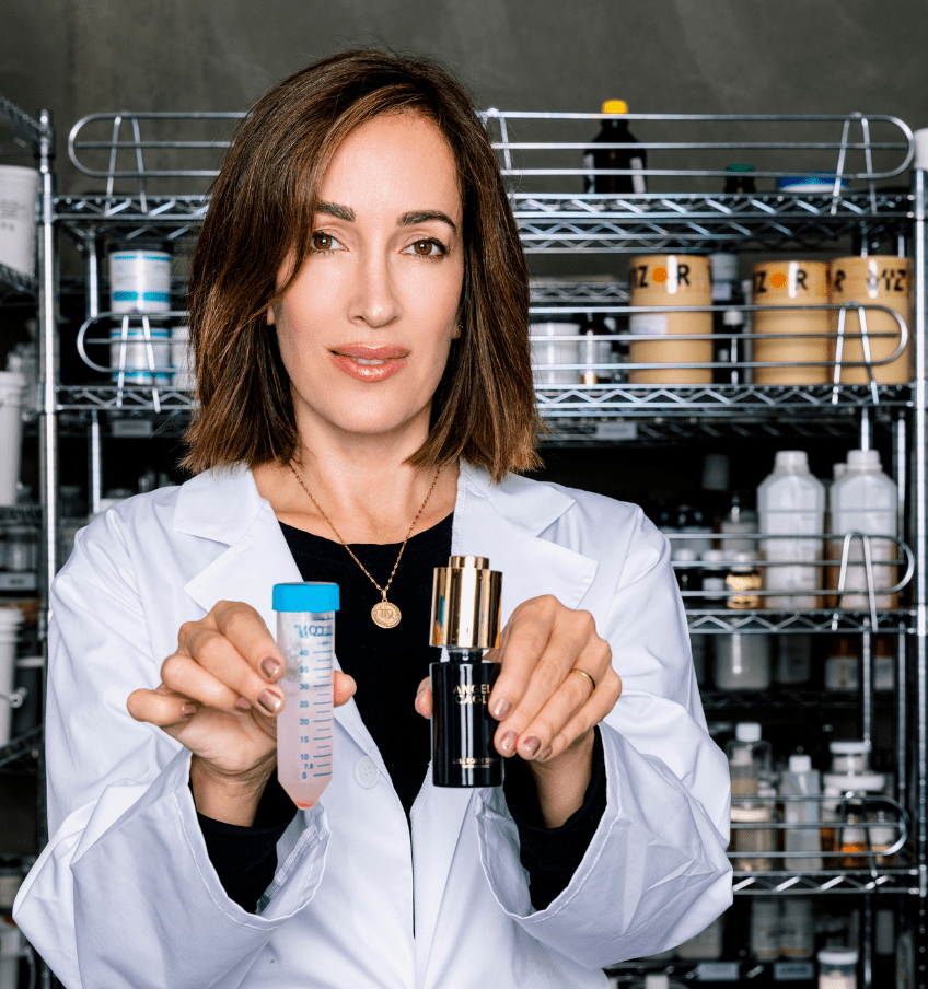 Angela in white lab coat holding cell forte serum