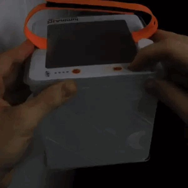 LuminAID lantern being turned on in red mode
