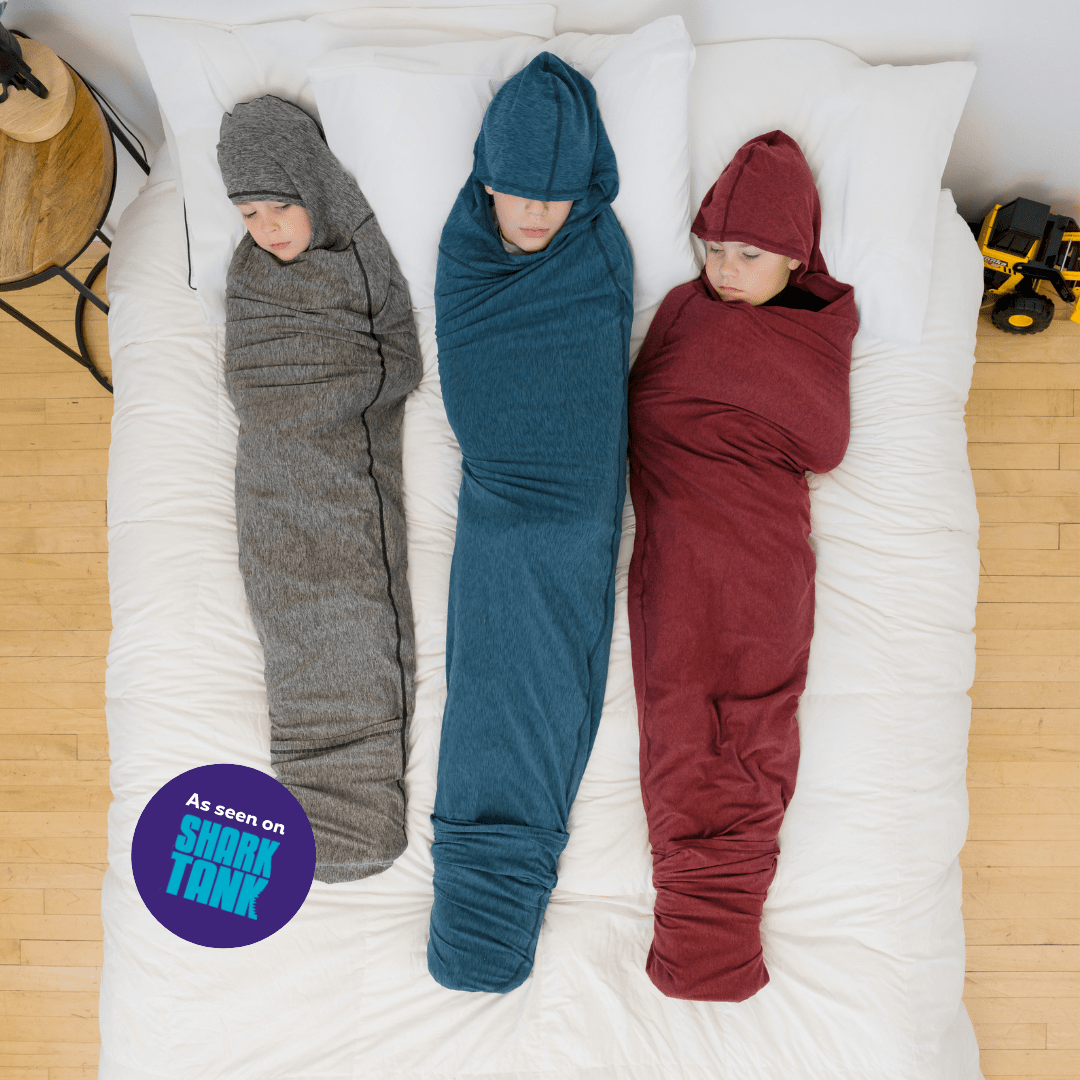 Woman sleeping in sleep pod on bed with hood up over face