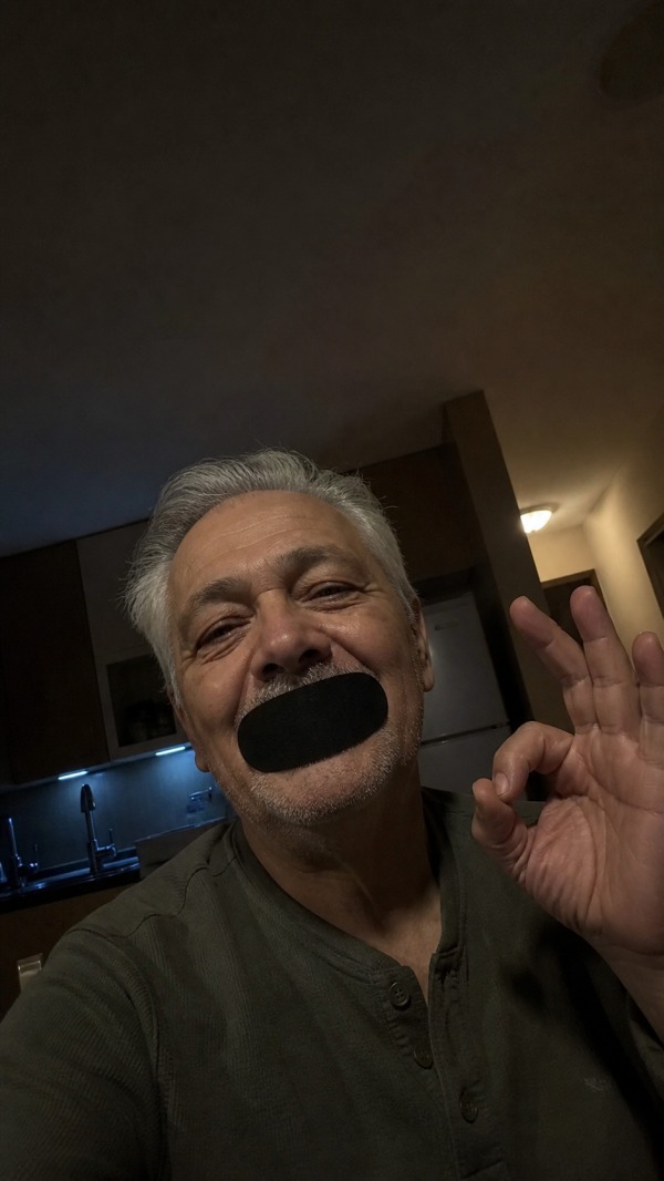 Rafael, age 60, wearing a black mouth strip