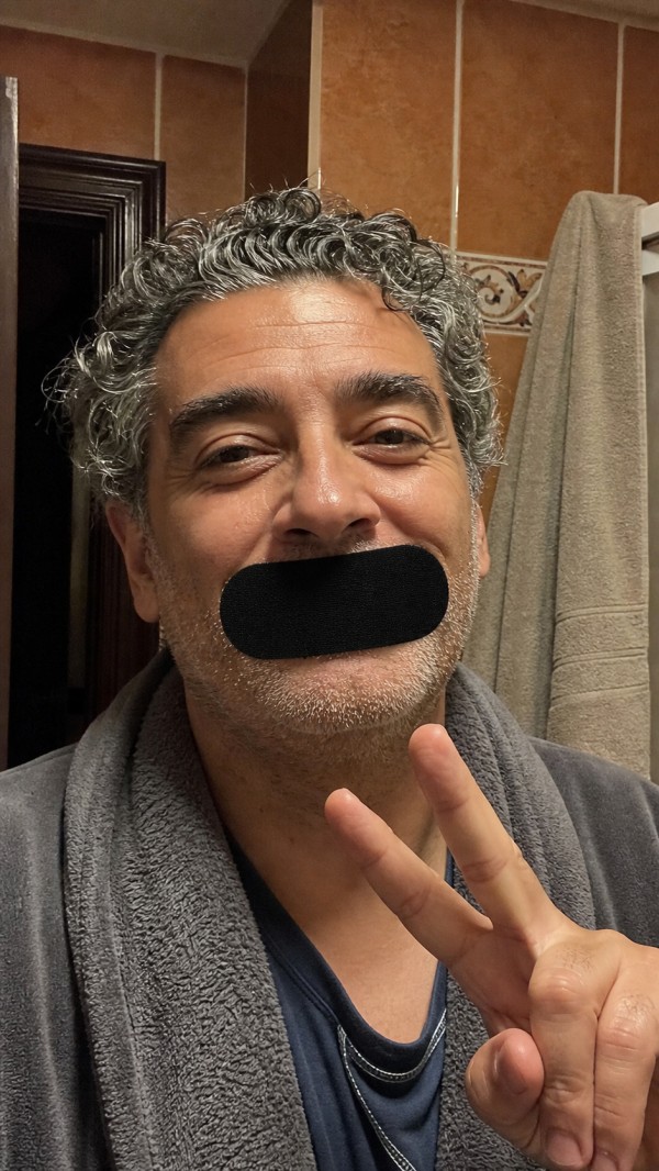 Fernando, age 51, wearing a black mouth strip