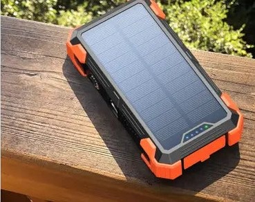 The power bank lying panel-up in daylight on a wooden surface.