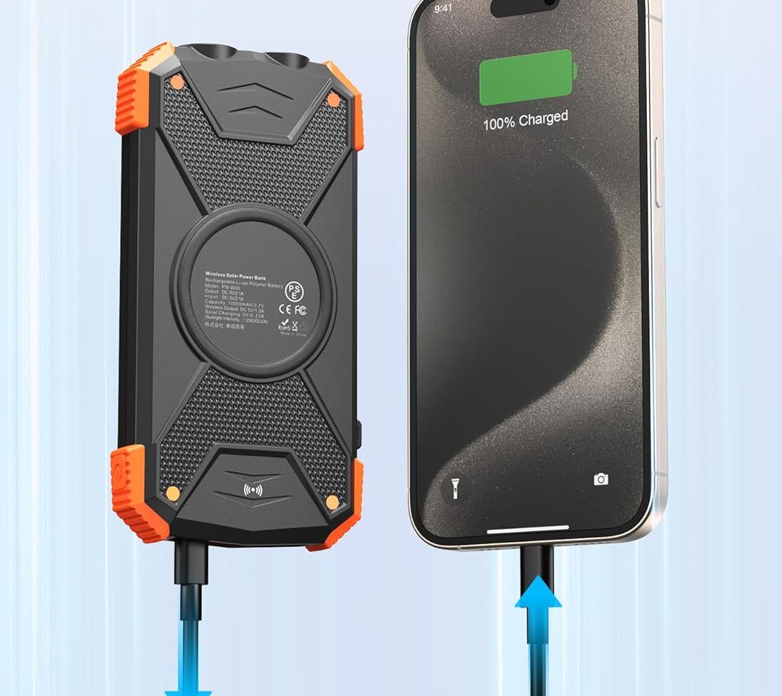 The power bank's printed spec label beside a phone showing a full charge.
